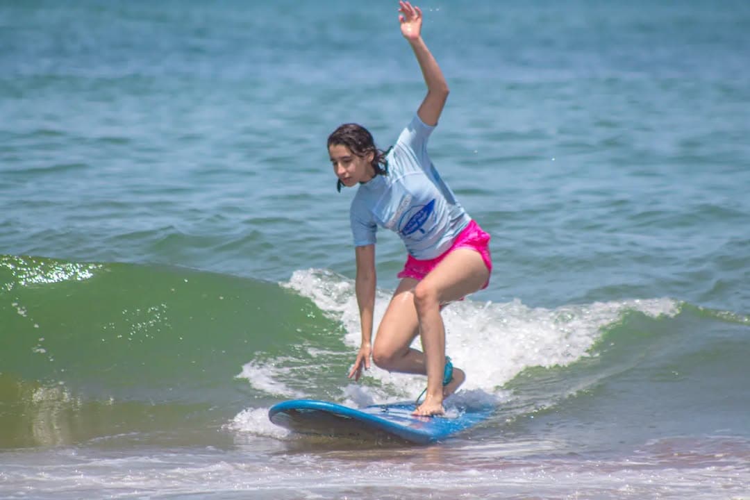 Young surfer riding a wave with instructor