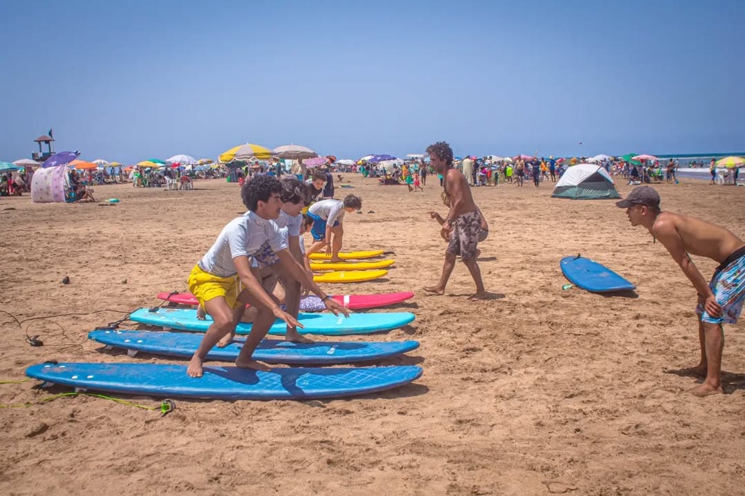 Group running on beach during surf lesson
